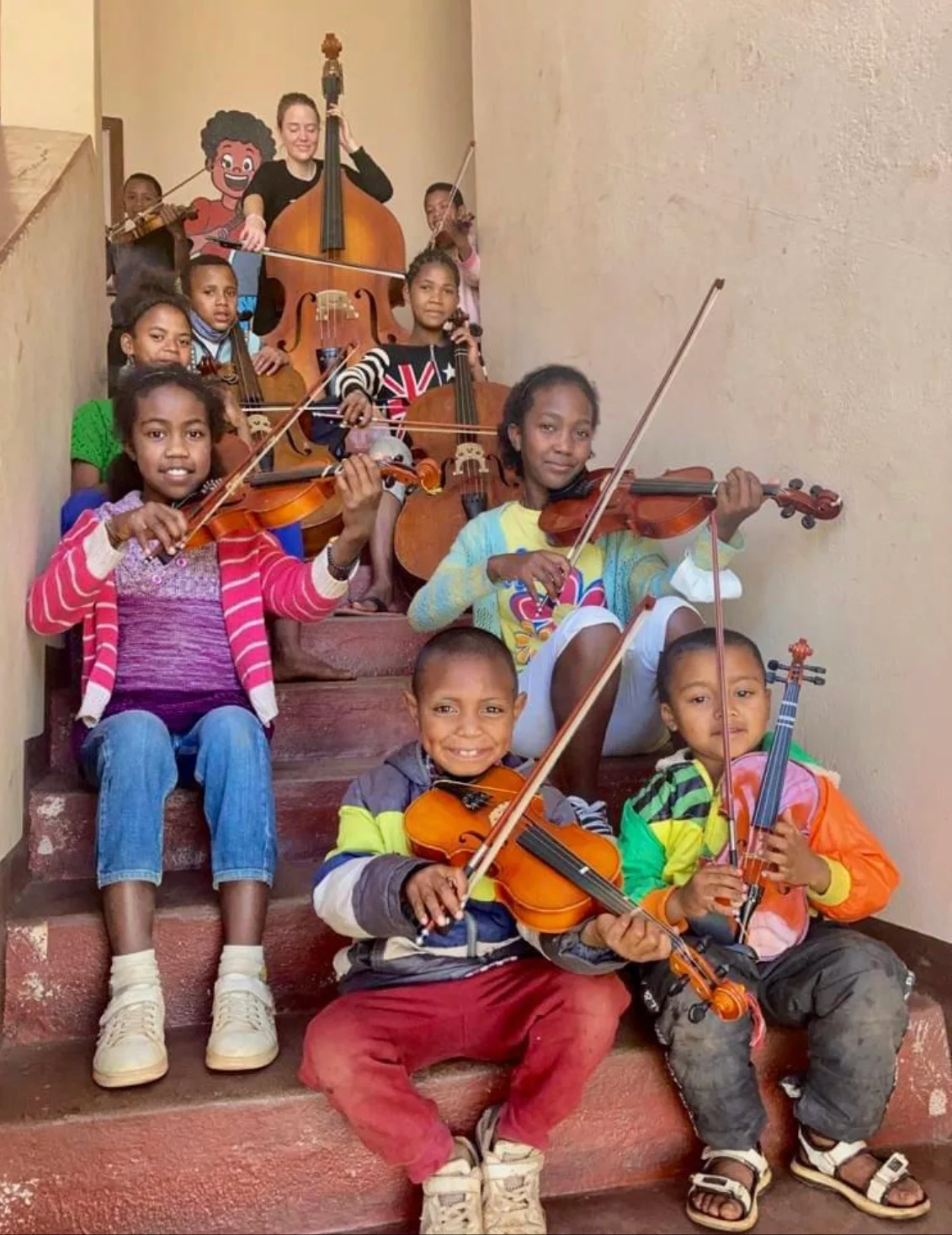 Teacher and her students playing cello and violin